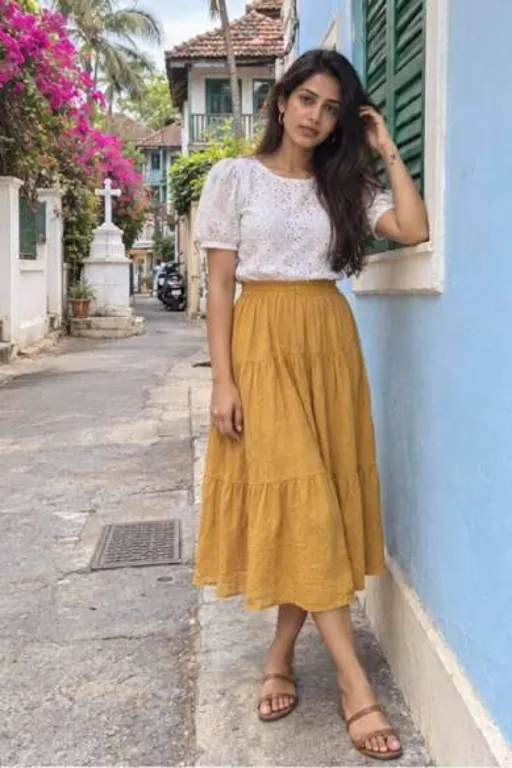 Riya, 24, call girl in Bandra, Mumbai: leaning on a blue wall in an old Bandra lane in a white top and mustard skirt